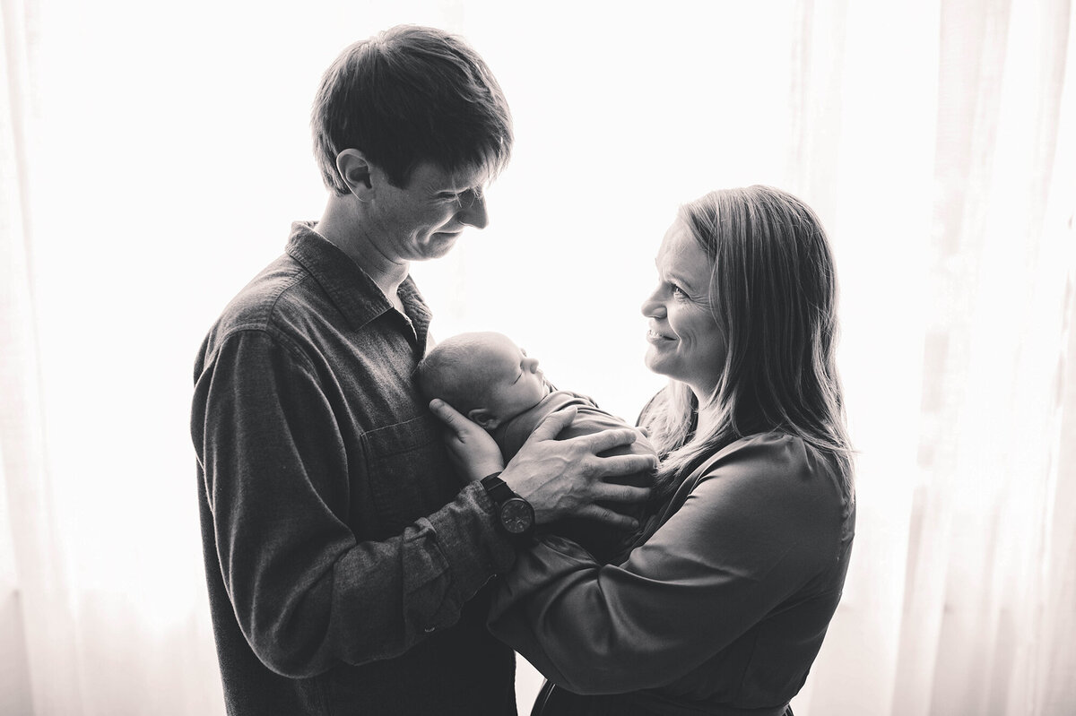 New parents hold their infant during Charleston Newborn Photos.