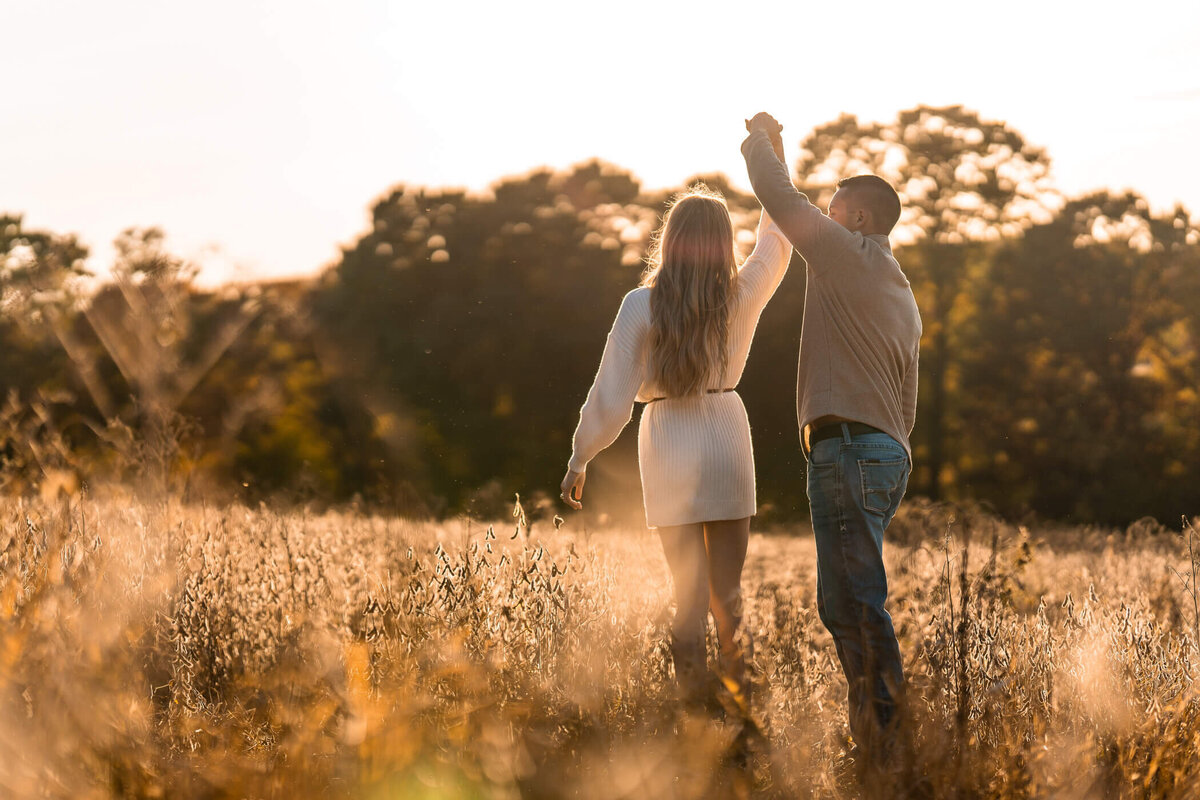 Sunset natural light portrait of a couple dancing in a field during their engagement session near beaver falls, PA. Captured by Pittsburgh Engagement Photographer Michael Fricke Photography.