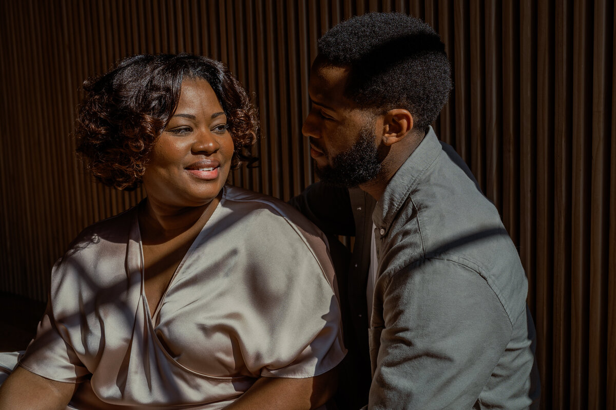 A heartfelt portrait of a mom and dad sharing a warm moment, illuminated by golden sunlight during an NYC family session.