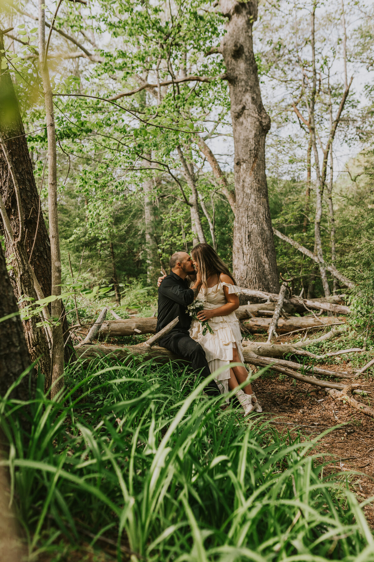 Couple in wooded area, capturing natural love story in Indiana engagement.
