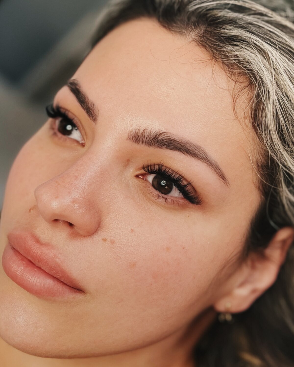Client showing healed lashes and powder brows for a natural finish.