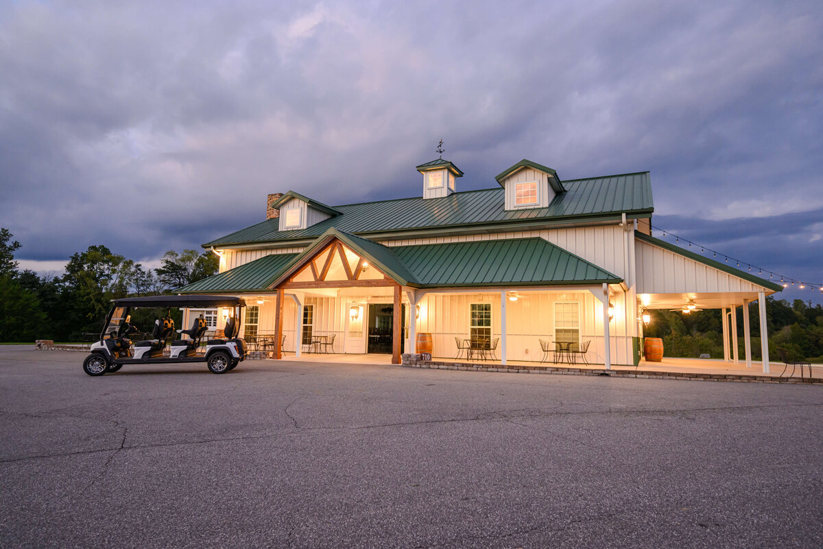 A beautifully lit wedding and event venue with a green metal roof, captured at twilight at Willow and Stone Events, just outside Charlotte, NC.