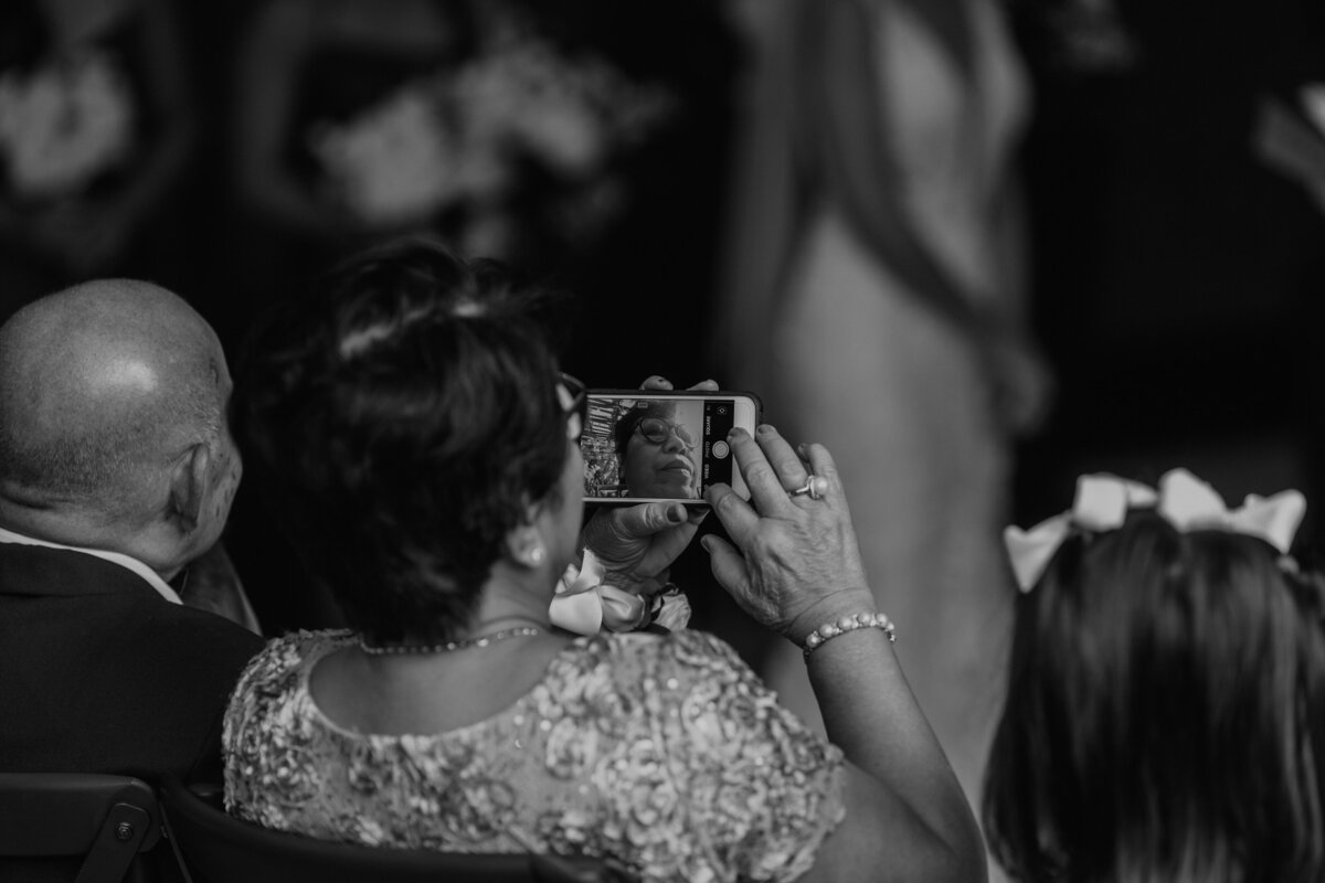 Mother of the groom holding  iPhone the wrong way to take photo