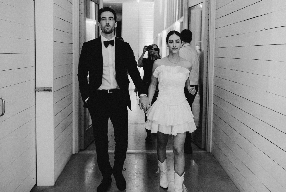 Bride and groom walking through hallway at Prospect House wedding, Austin