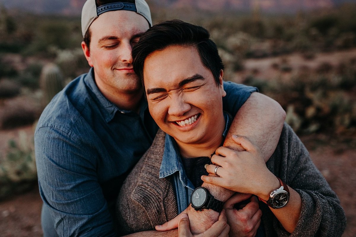 two men bear hug one another in smiling embrace in the Phoenix desert