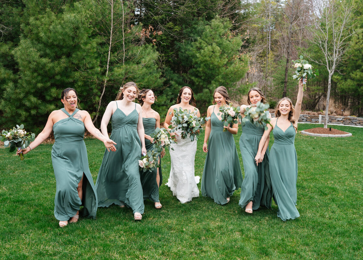Bride and groom walking hand in hand at their outdoor New England wedding