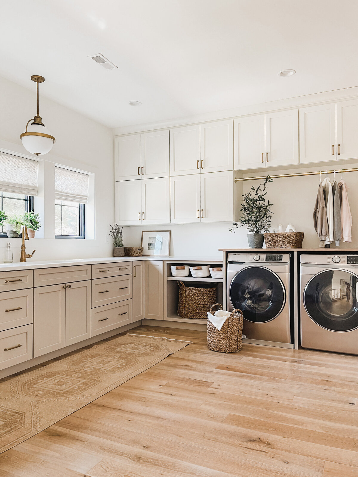 The large laundry room features ample custom cabinetry and a prep sink for washing delicates