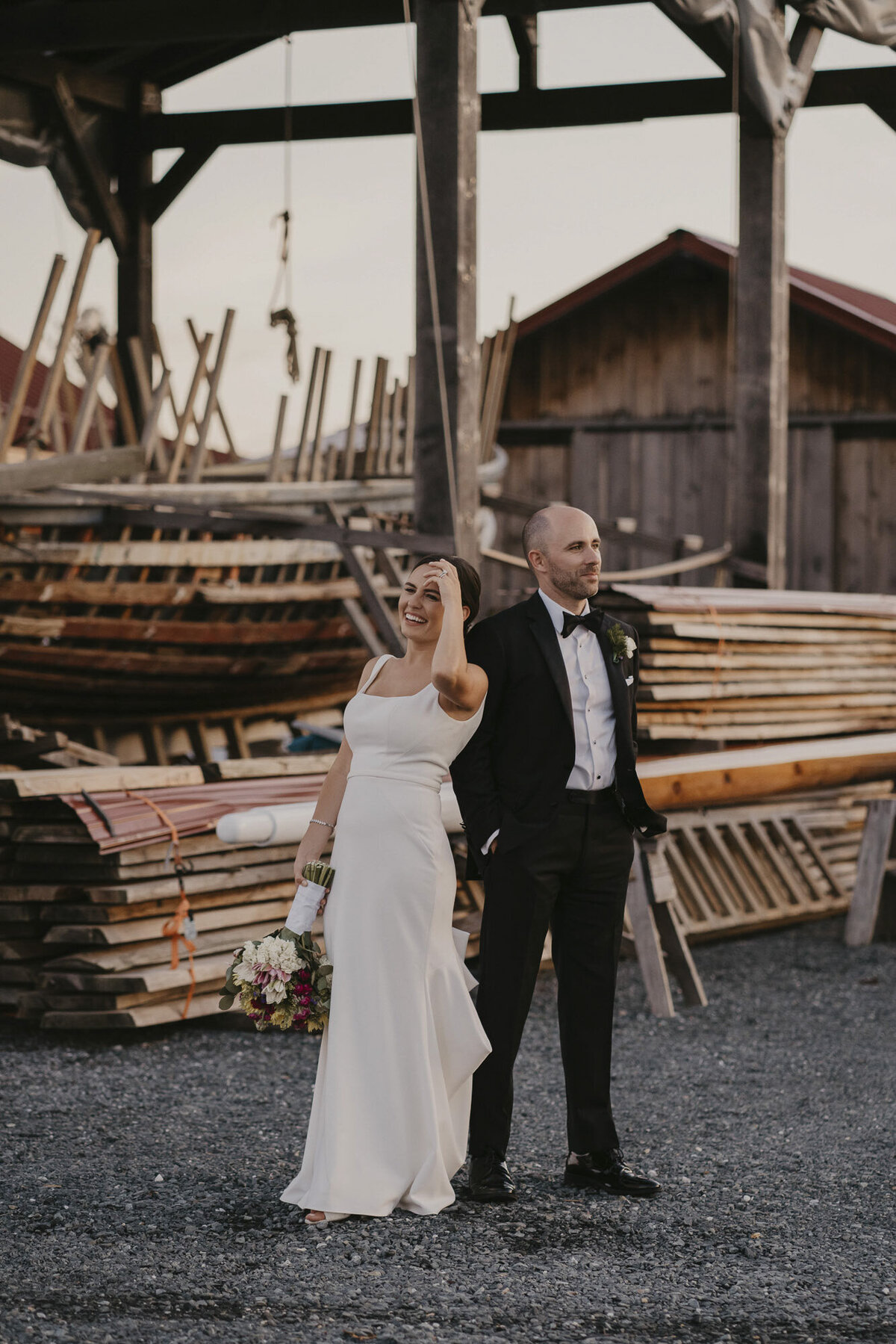 Bride and groom standing near piles of wood