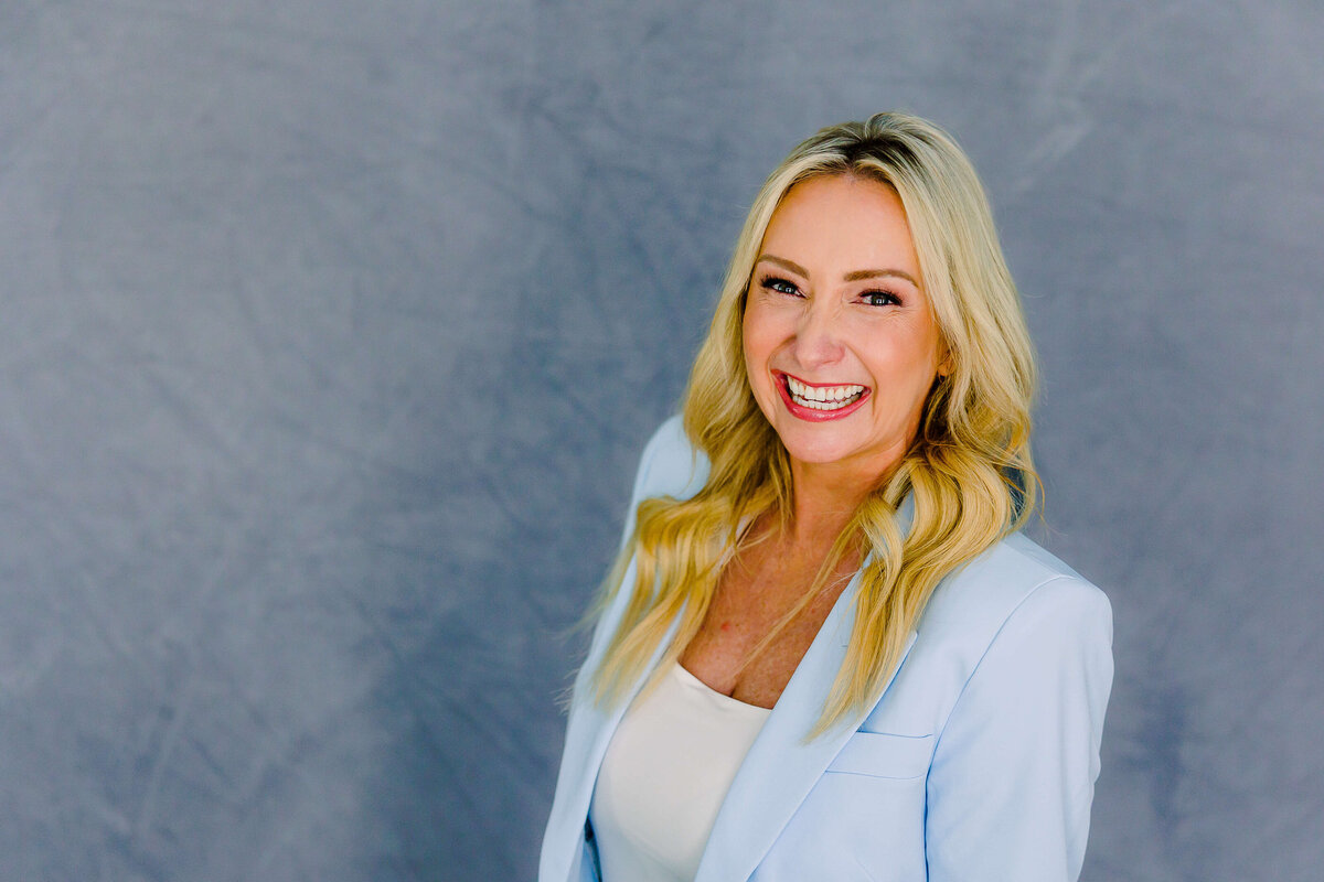 Business photo of lady laughing at the camera wearing blue