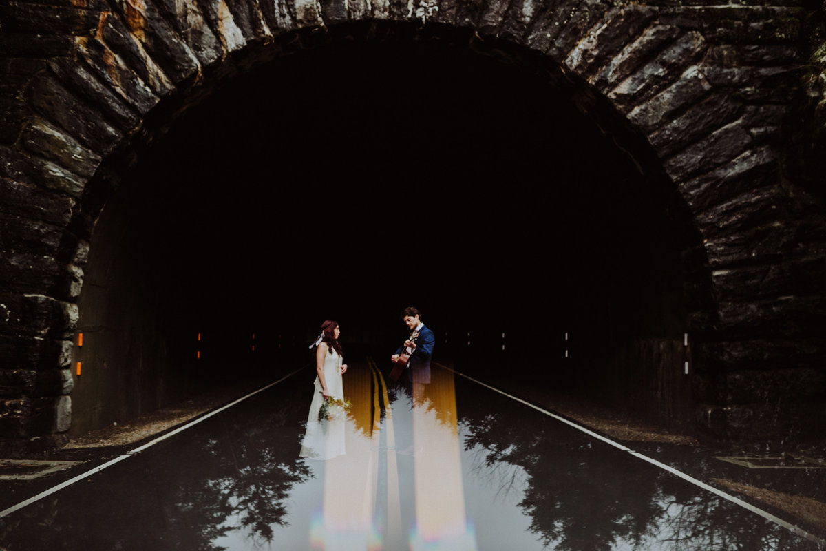 Groom playing guitar for his bride at the Devil's Courhouse Tunnel on Blue Ridge Parkway