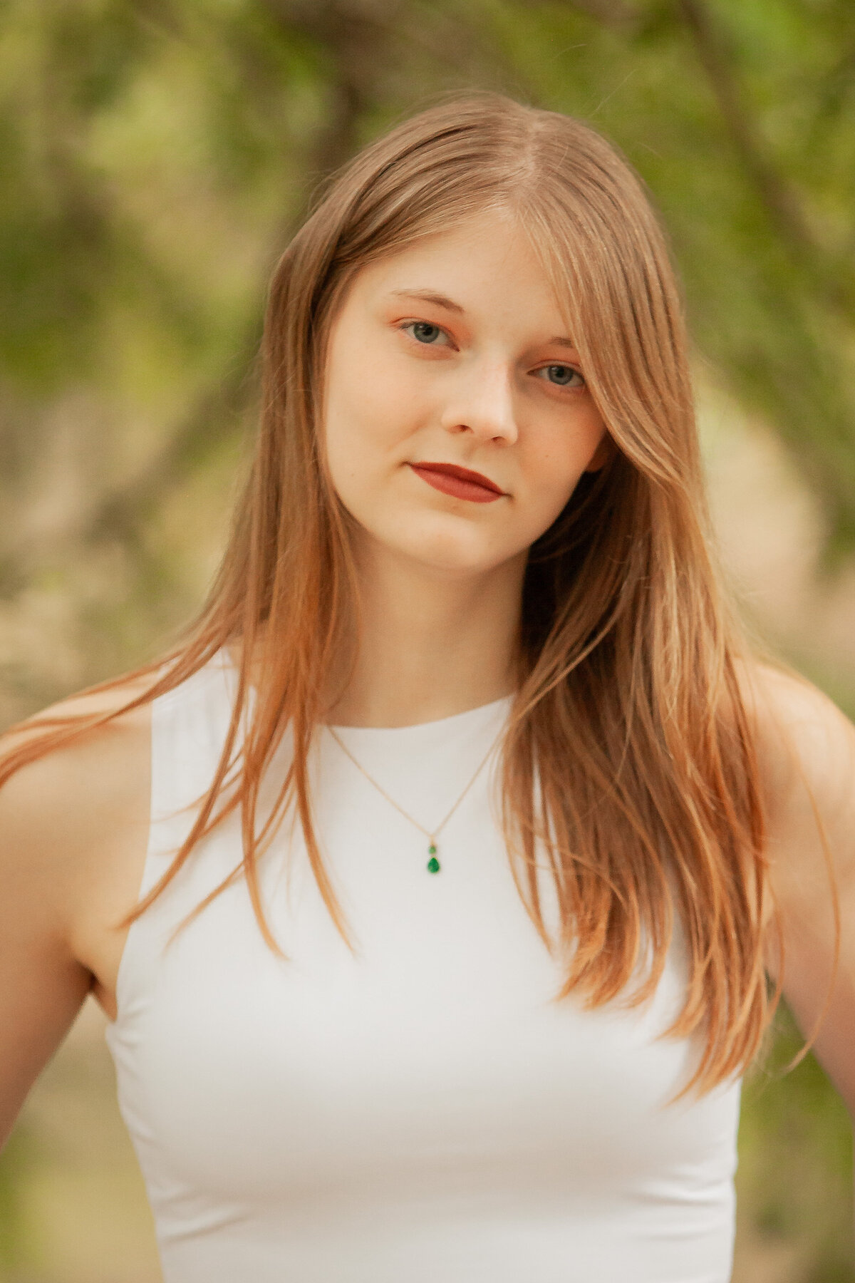 Girl with green necklace and white shirt with green background looks like taylor swift