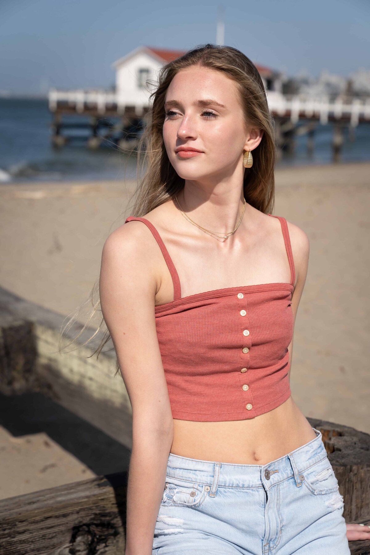 Attractive model posing at the beach wearing jeans and a tank top.