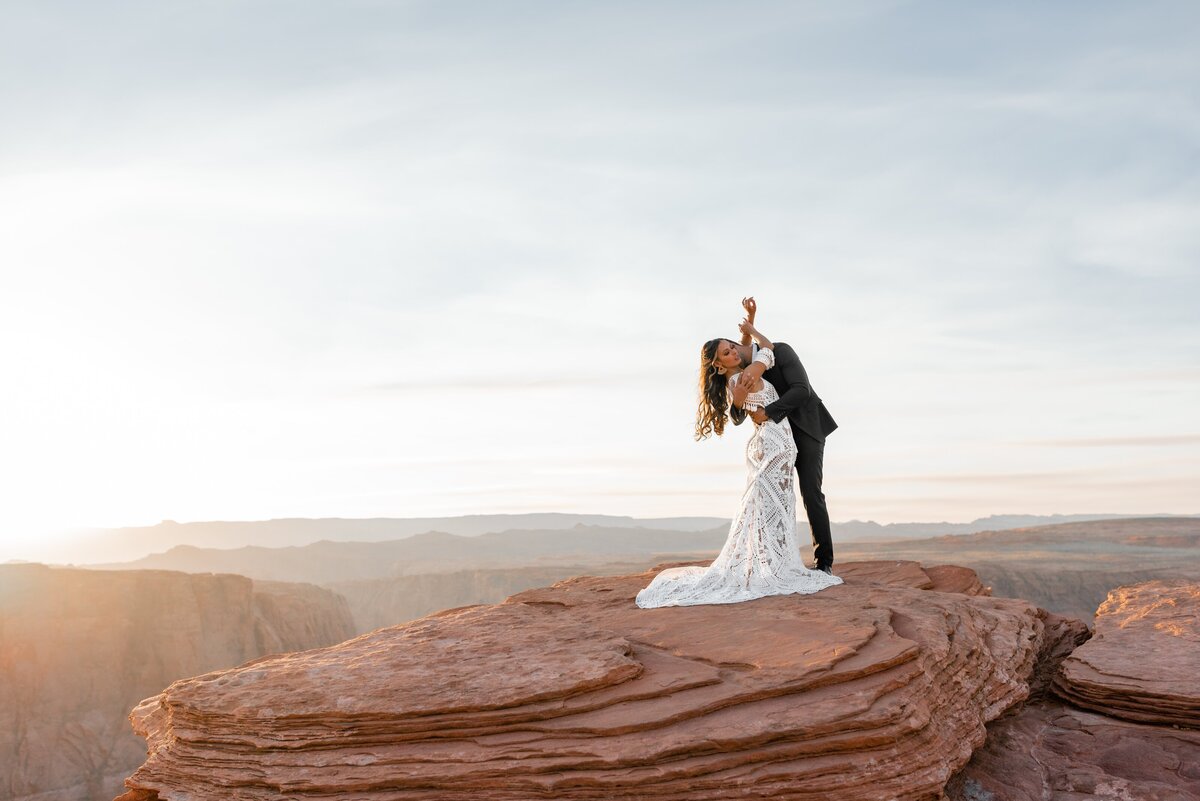 Newlyweds holding each other on a mountaintop