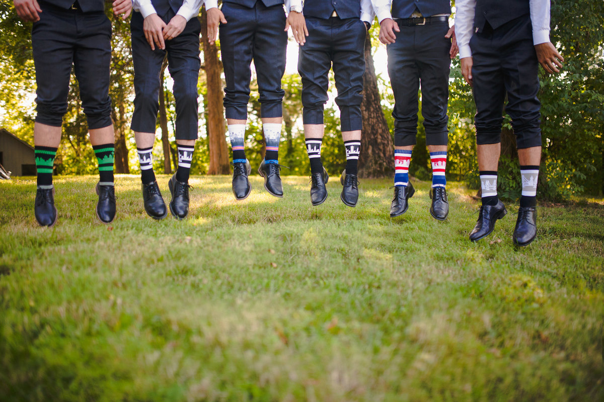 Groomsmen show off their crazy socks by jumping in the air.