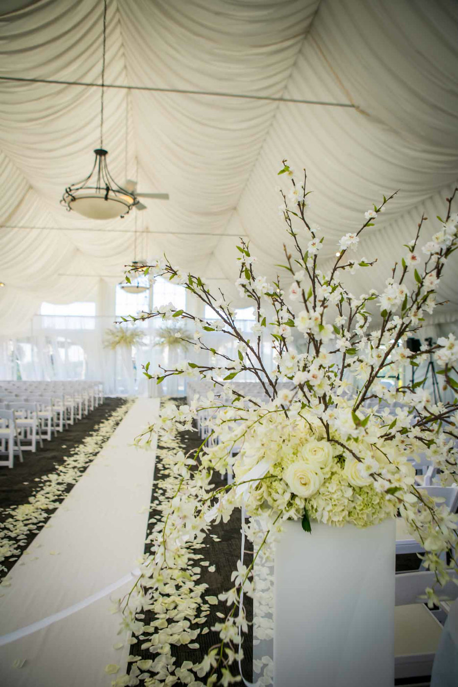 wedding ceremony in tent with cherry blossom arrangements