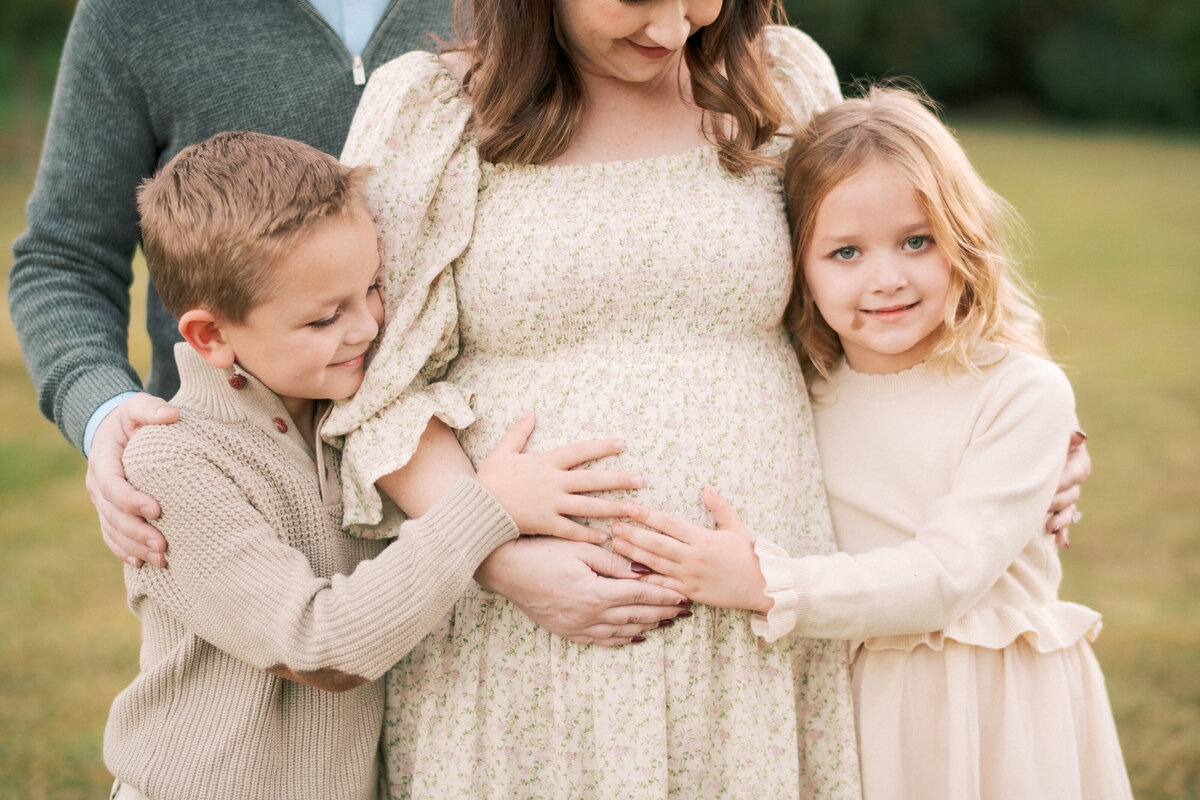 Big siblings cuddle mom's belly during a maternity session at Oak View Park. Image by Raleigh maternity photographer A.J. Dunlap Photography.
