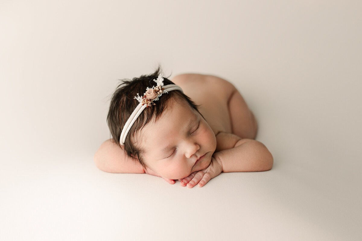 Sleeping newborn in headband studio session 