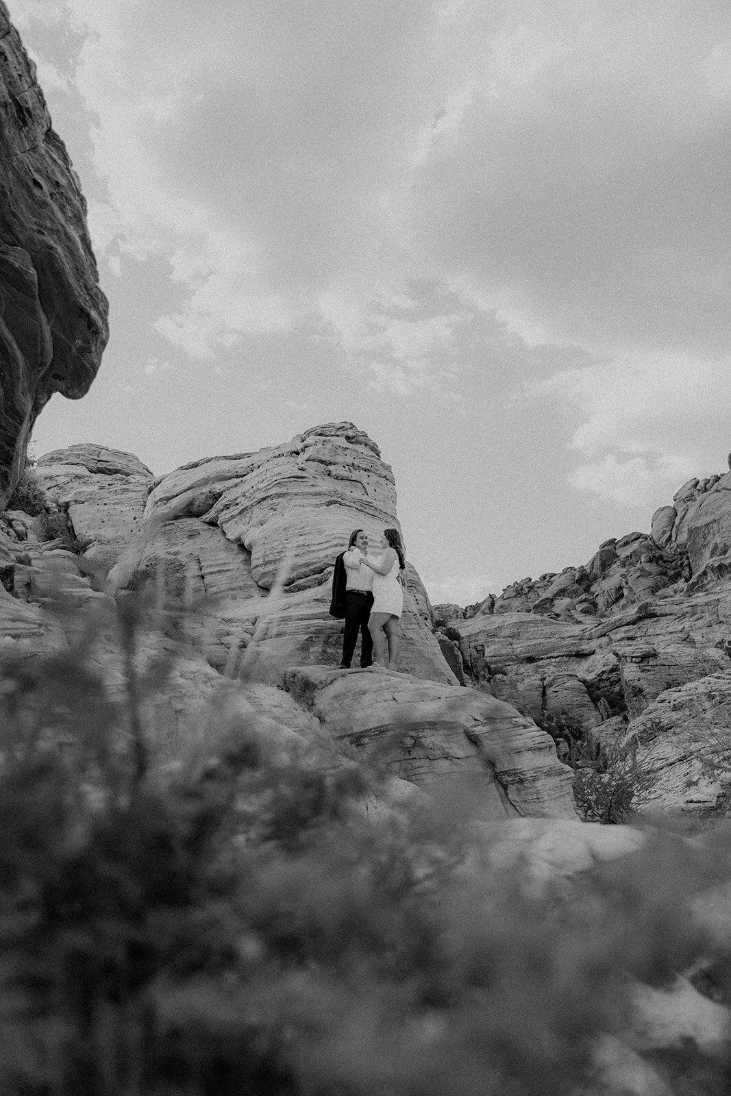 Black and white Portrait  image of engaged couple on a rock at the Red Rock Canyon