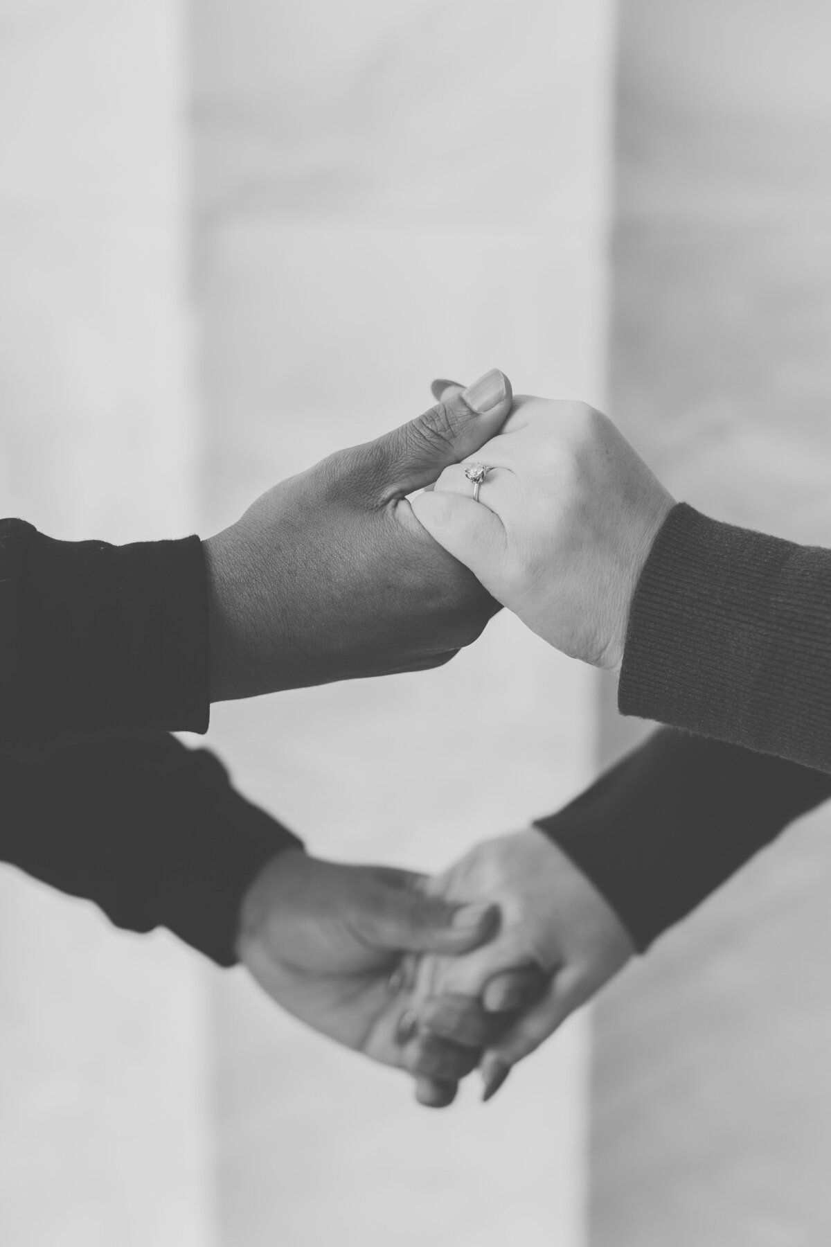 Black and white close-up of bride and groom holding hands during elegant Carolina Home and Garden Wedding. 