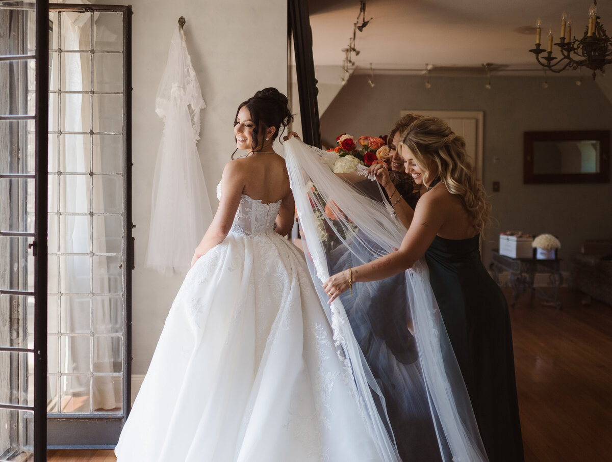 Mother of the bride and maid of honor getting the bride ready