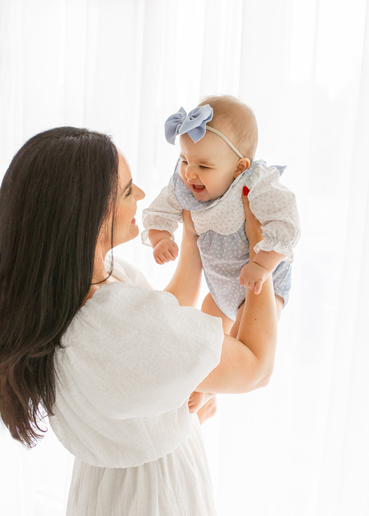 mom  swinging baby girl in air