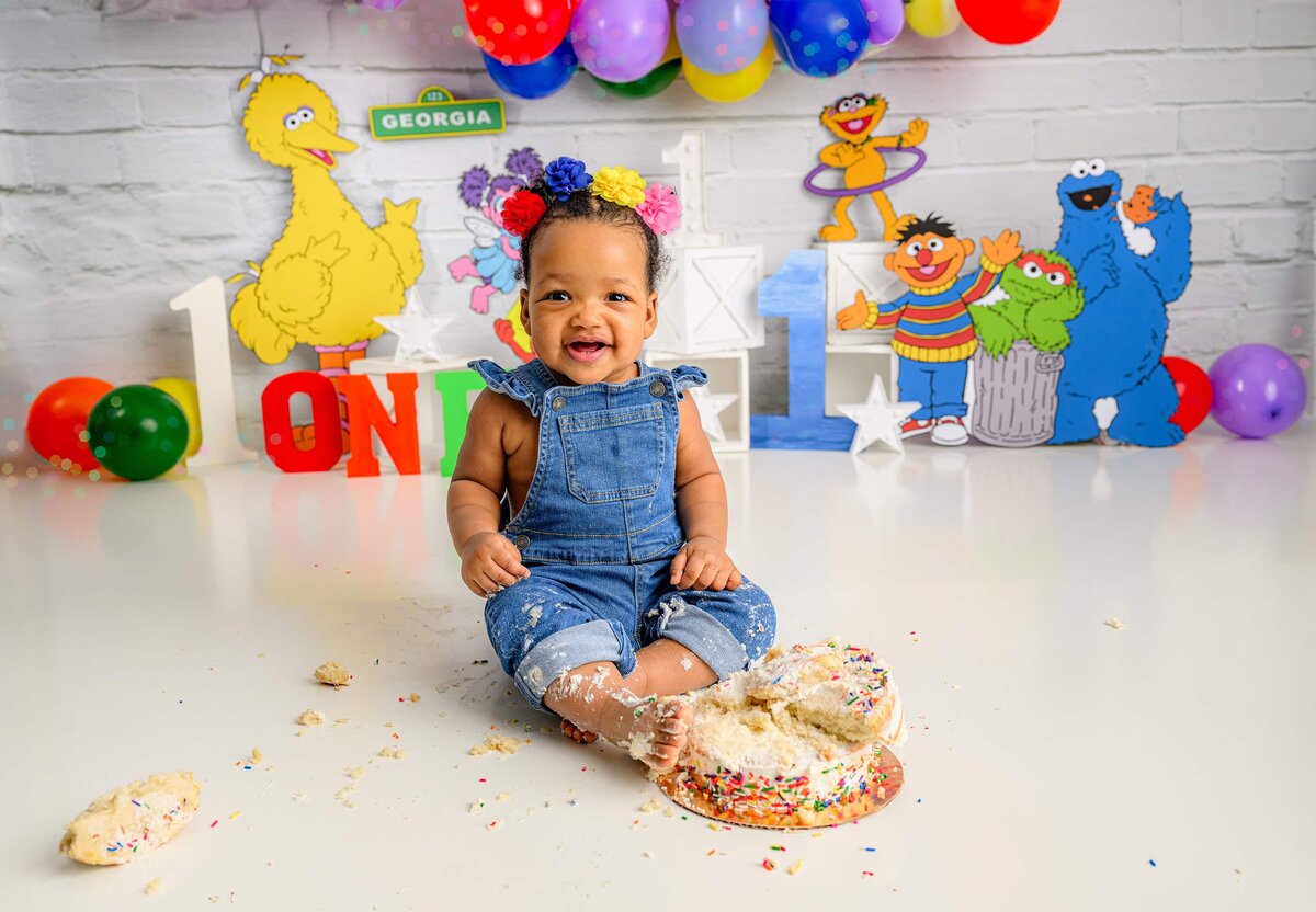 birthday photoshoot in a sesame street themed cake smash