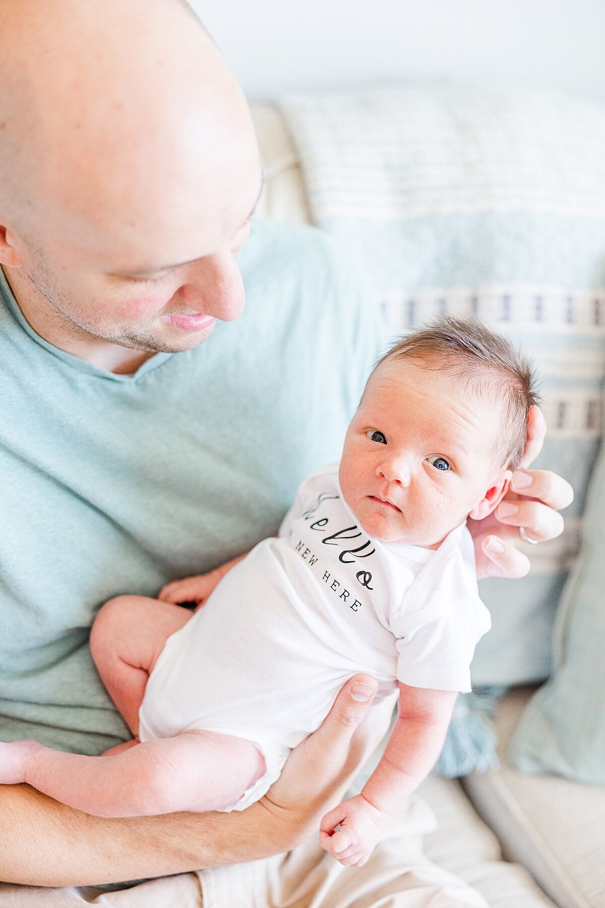 dad holds baby  during in home newborn photo session with Sara Sniderman Photography in Metro West Boston Massachusetts