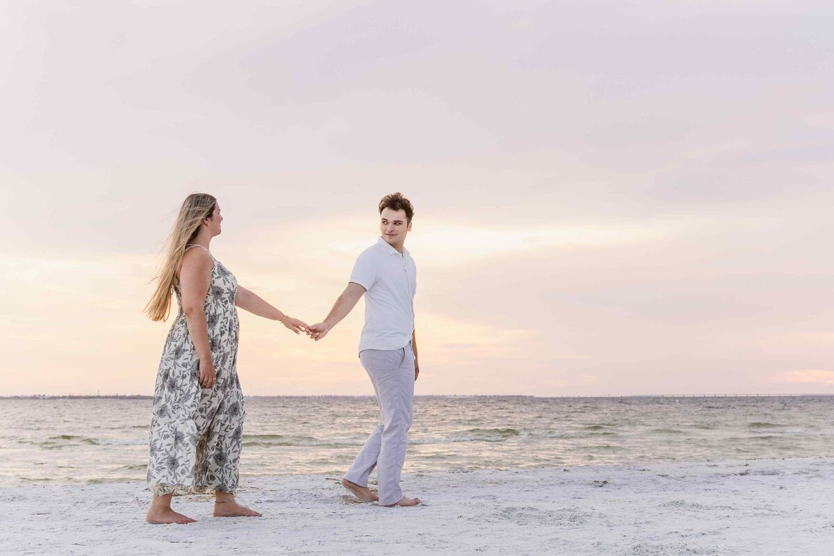man-leads-fiance-beach