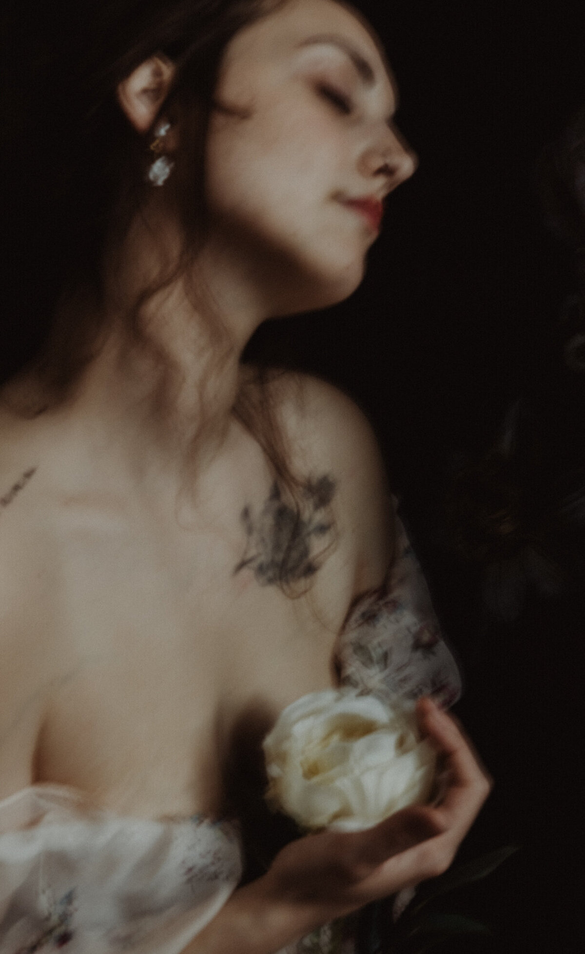 Ritratto di donna che tiene una peonia bianca, indossa abito floreale leggero – stile fine art.