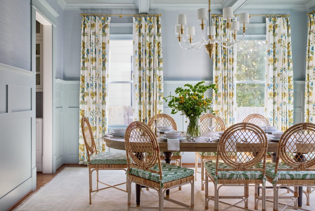 vision and hammer dining toom with floral curtains and wooden table