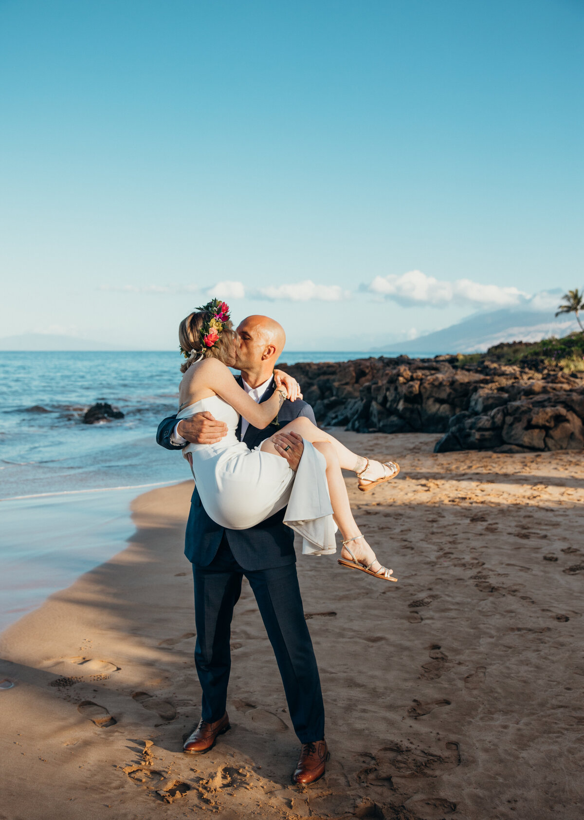 Maui Wedding Photographer captures groom holding bride while kissing her