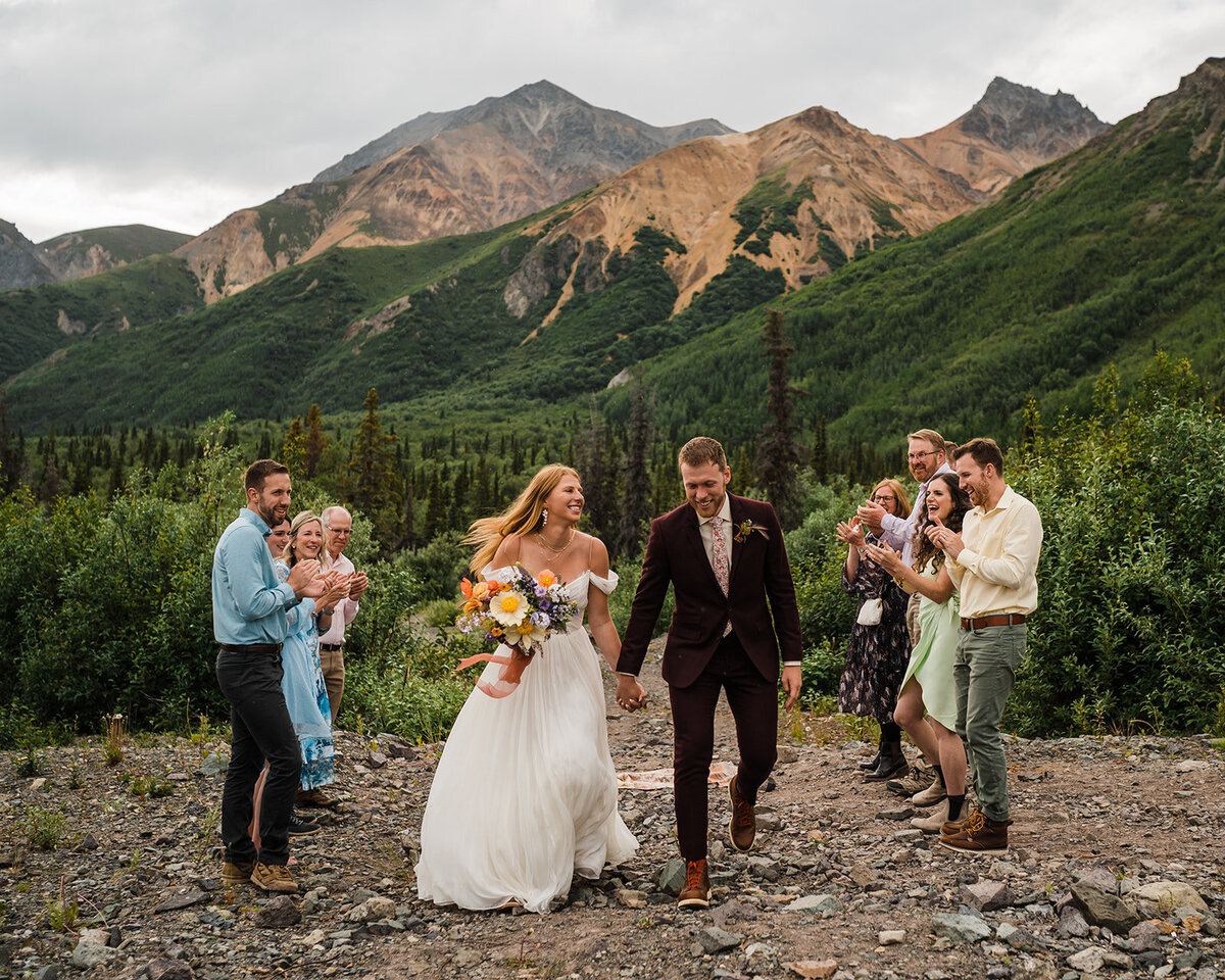 Bride & groom smiling as they recess out of their intimate wedding ceremony near Sheep Mountain Lodge in Alaska!