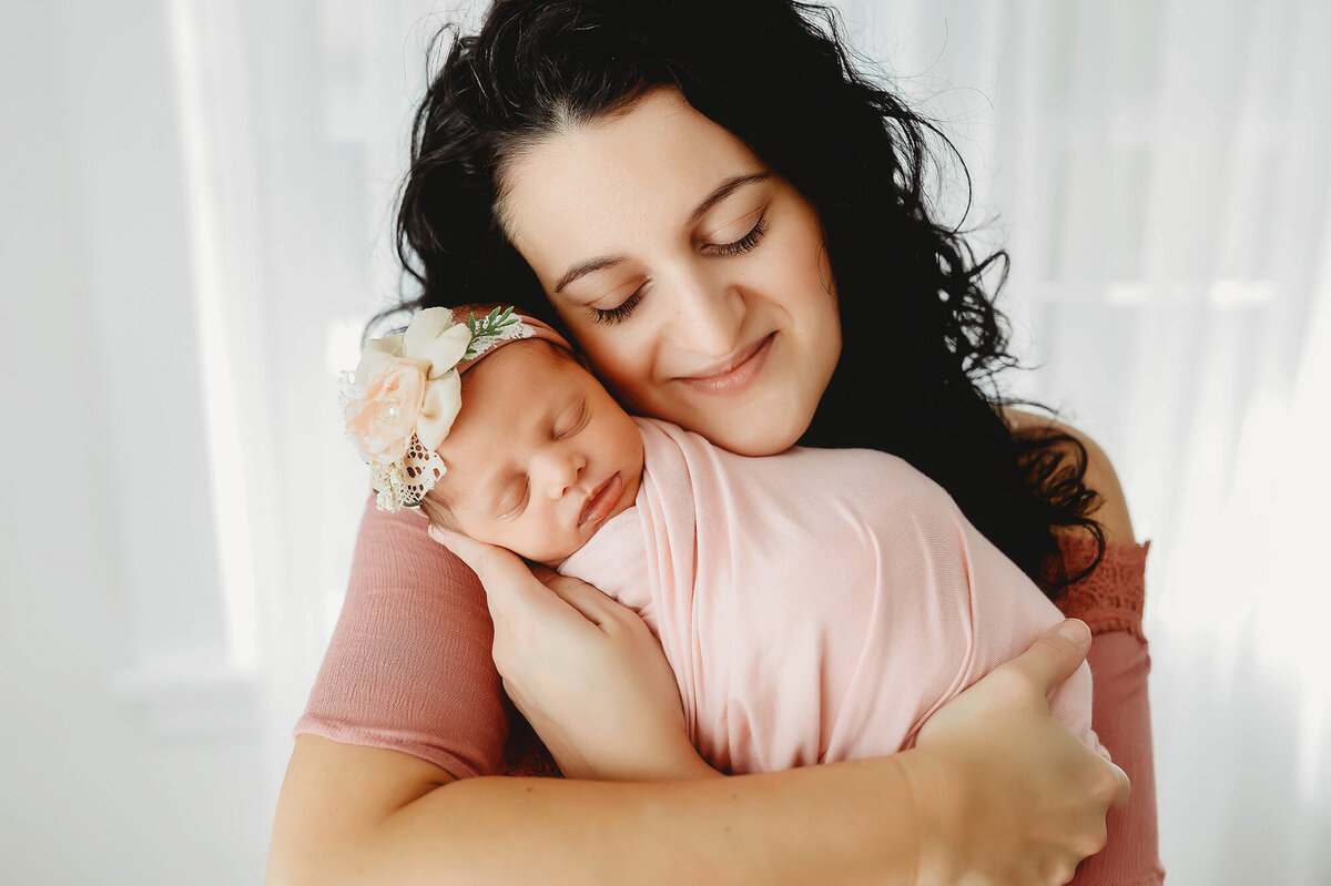 Mother embraces her baby during Newborn Photoshoot in Asheville, NC.