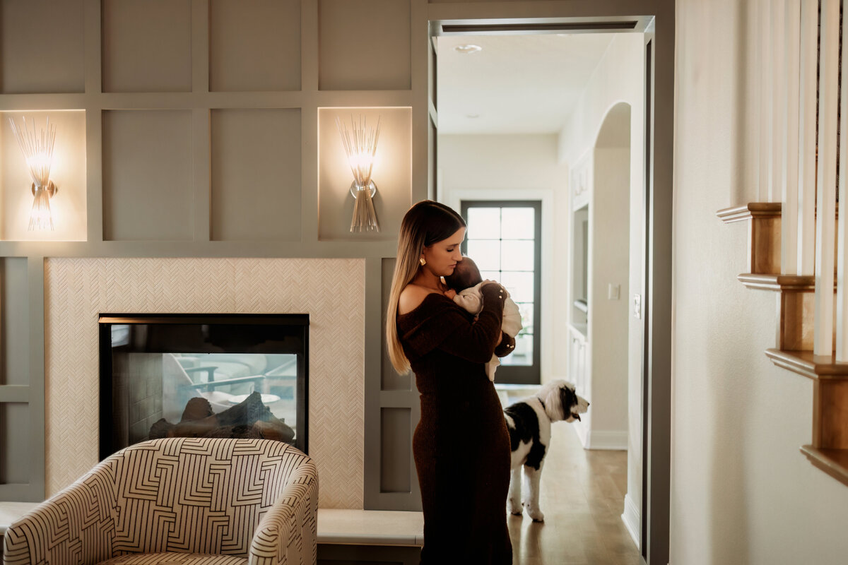 Mom walking baby to sleep in living room hallway