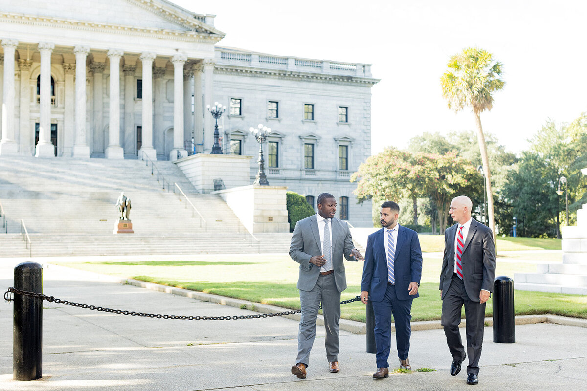 Columbia, SC business branding photo of the partners from Dayson, Shalibi, and Burkett law firm walking and conversing in front of the South Carolina State House, captured by Jessica Hunt Photography.