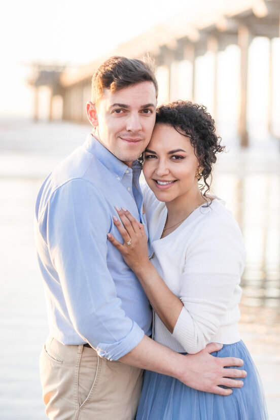 engaged-couple-hugging-in-front-of Scripps-Pier-San-Diego