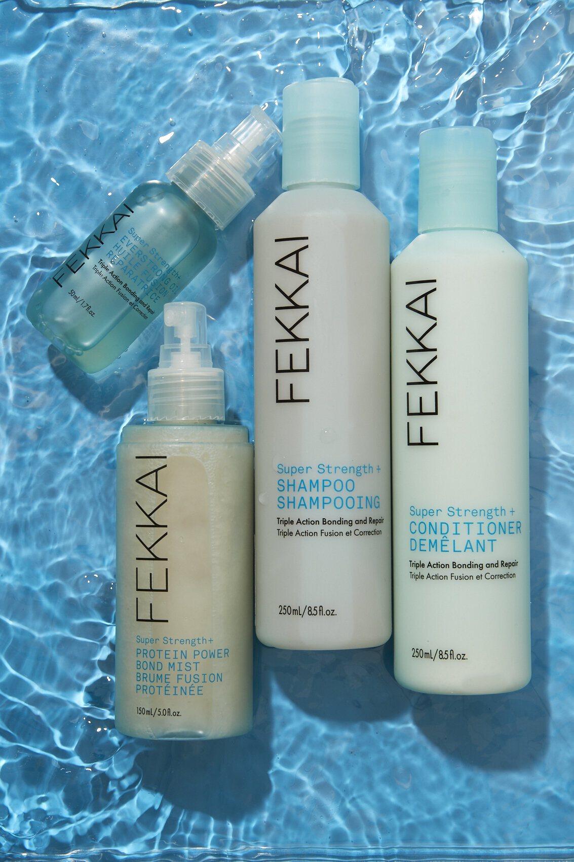 Flat-lay of Fekkai haircare products including shampoo and conditioner bottles, photographed against a vibrant blue backdrop by Ylva Erevall.