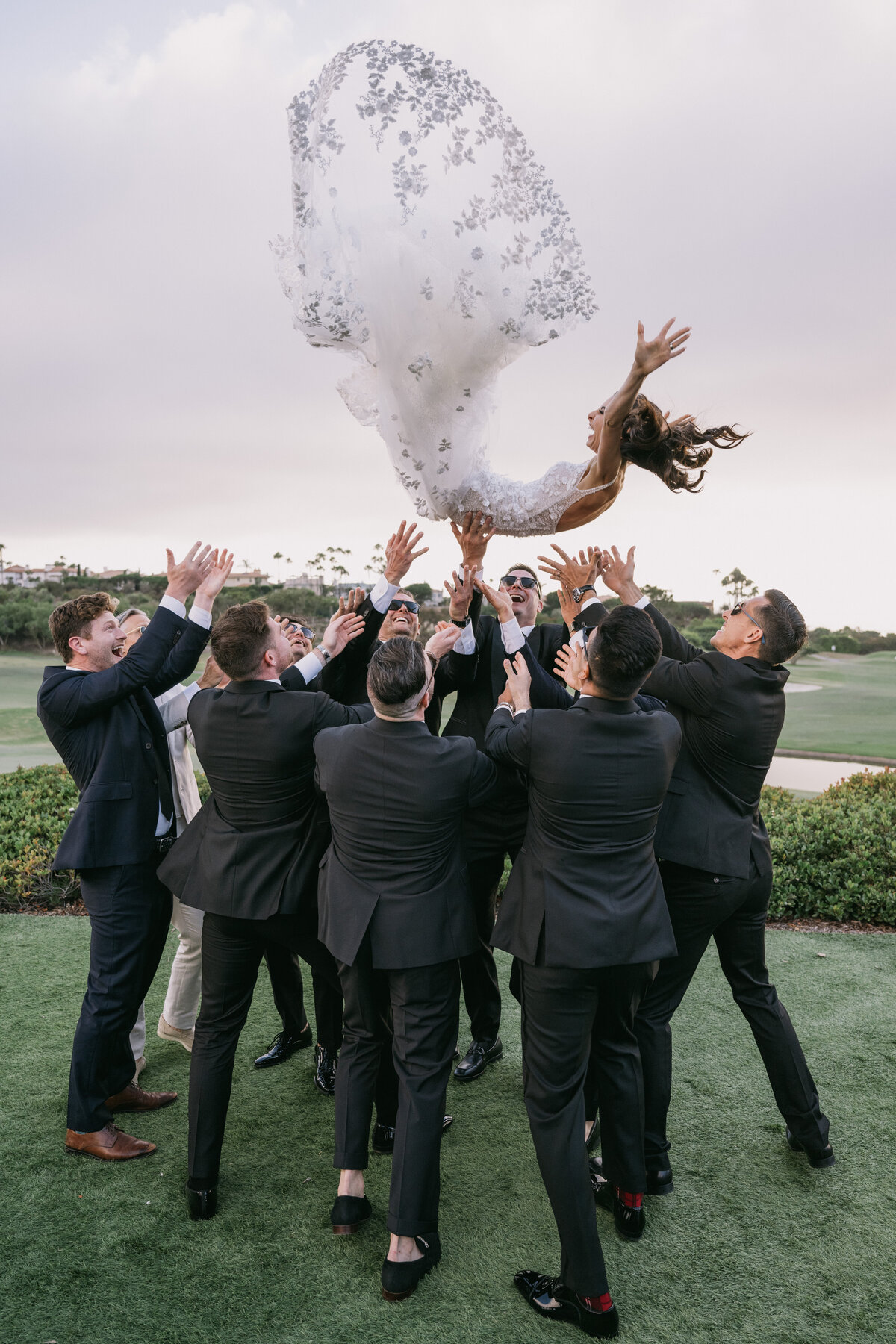 groomsmen throwing bride in the air
