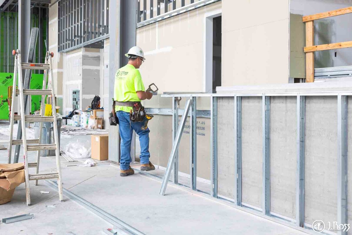 A J.Ross Painting & Drywall technician performing drywall installation on a new higher education building project.