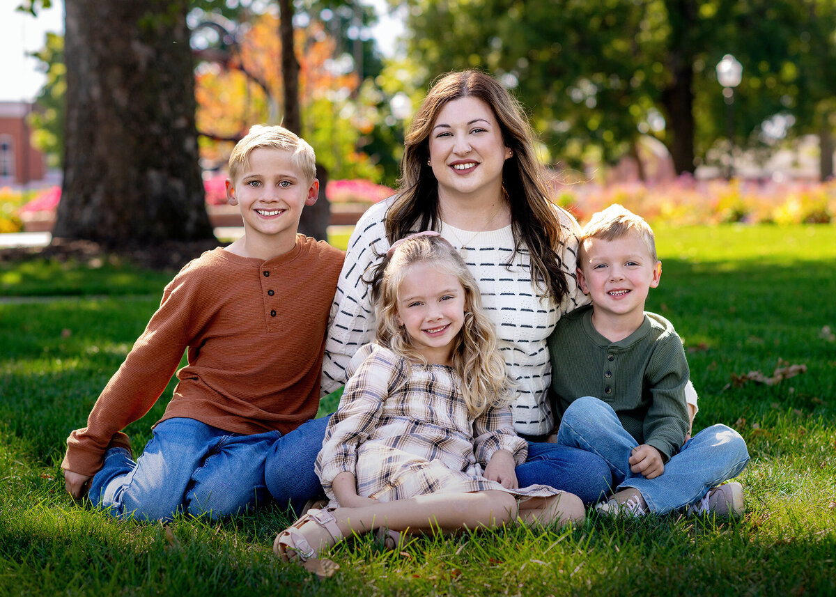 Mom and her 3 kids enjoying time together in a scenic garden surrounded by nature