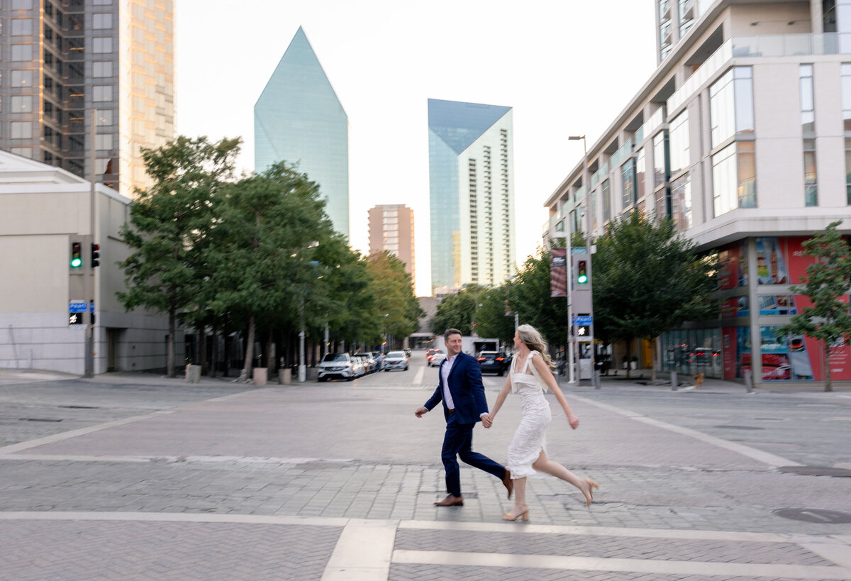 Engagement session at Winspear Opera House in Dallas Arts District couple running across the street by Kayleen Shearer Photography