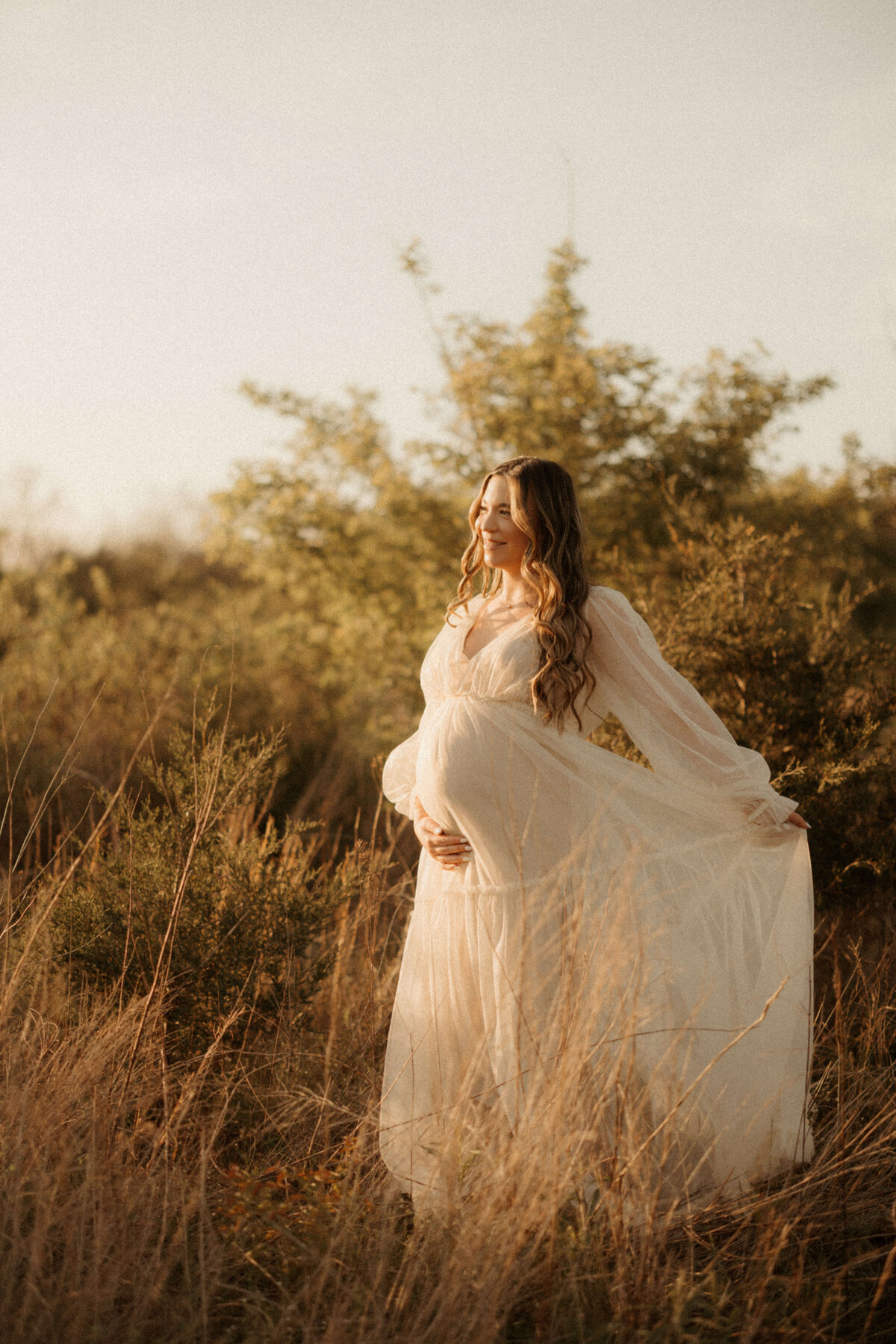 Pregnant woman holding belly during golden hour maternity session in Franklin TN