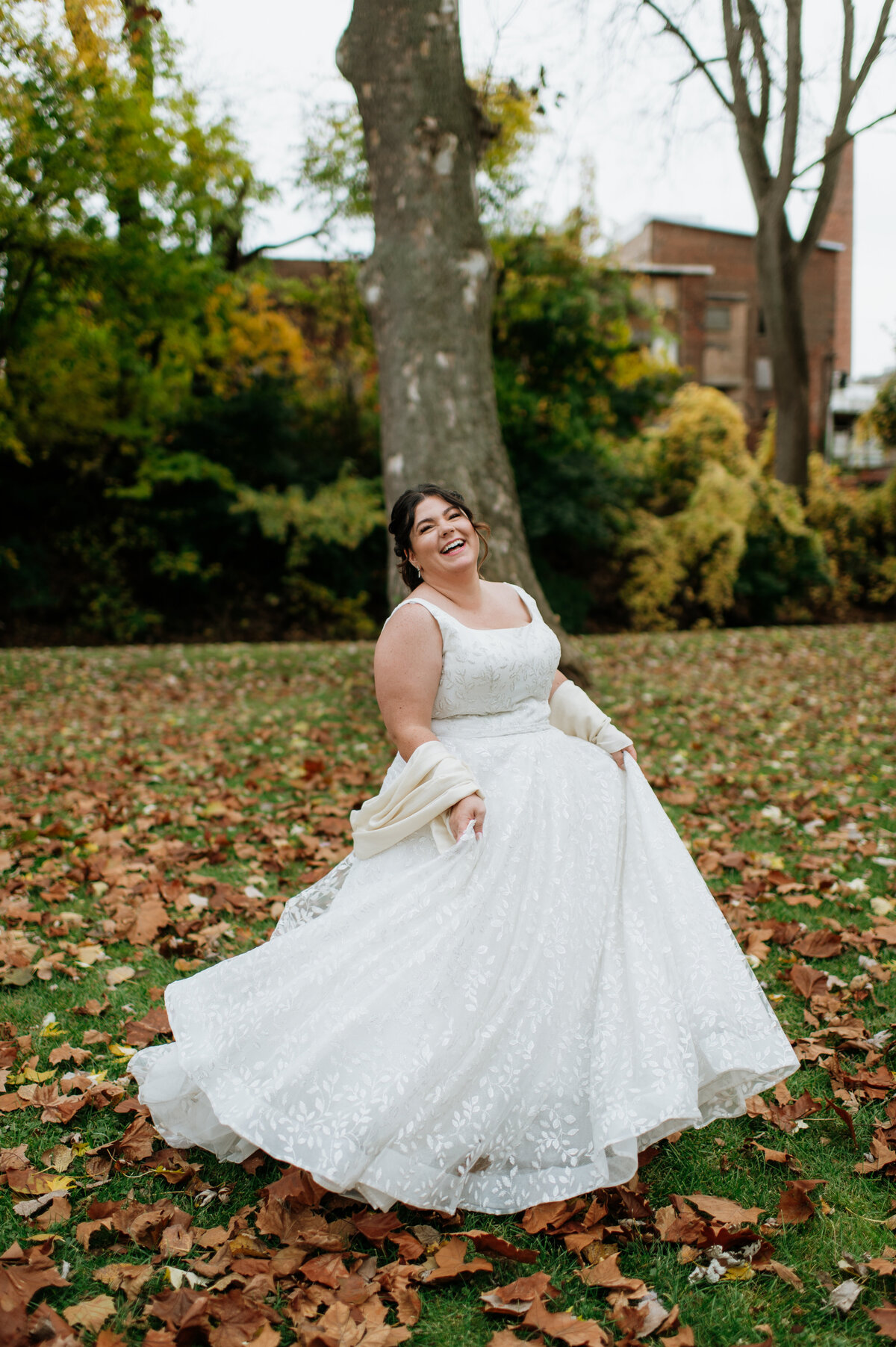 Bride twirling in fall leaves outdoor portrait