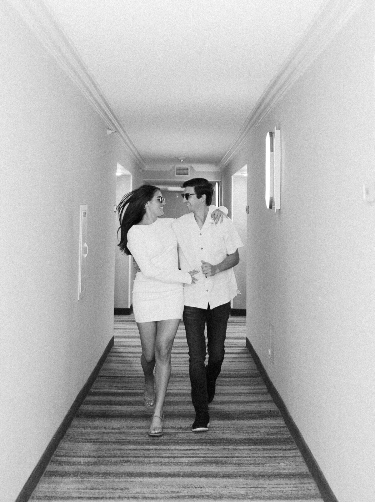 Couple walking in a hallway, photographed by Miami wedding photographer Claudia Amalia, illustrating her lifestyle and wedding photography skills.