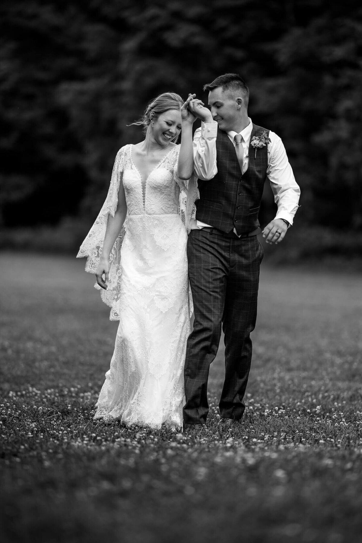 Black and white Pittsburgh wedding photos of bride and groom laughing and bumping into each other while holding hands. Captured at a wedding venue near Pittsburgh PA