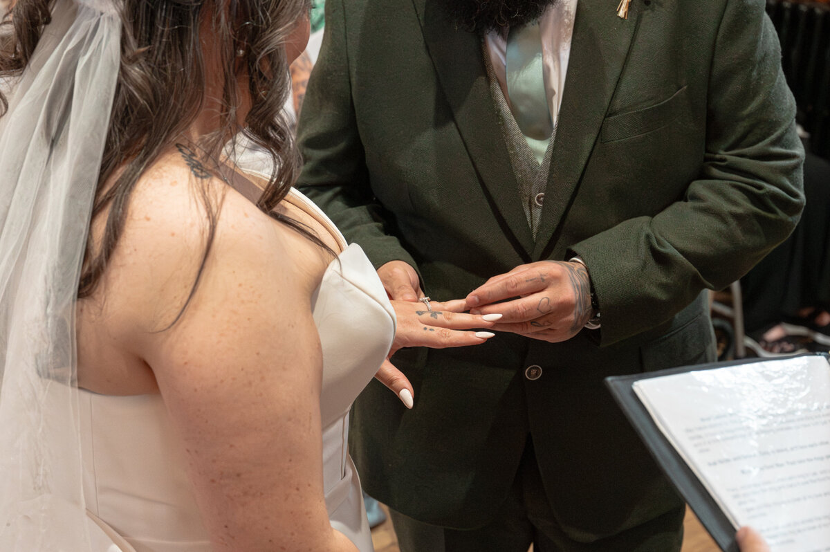 Bride and groom exchanging rings during ceremony in Worsley Court House ceremony room.