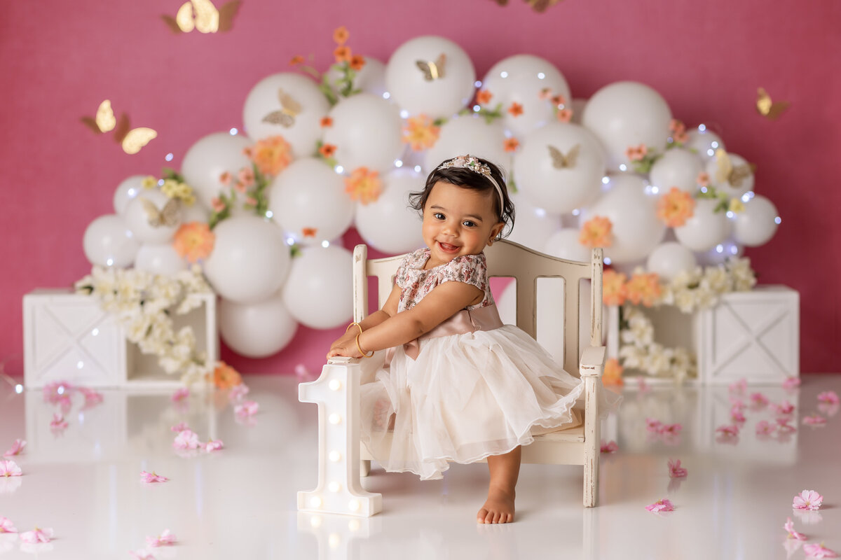 One year old Tampa baby enjoying a personalized luxury cake smash session with floral decorations