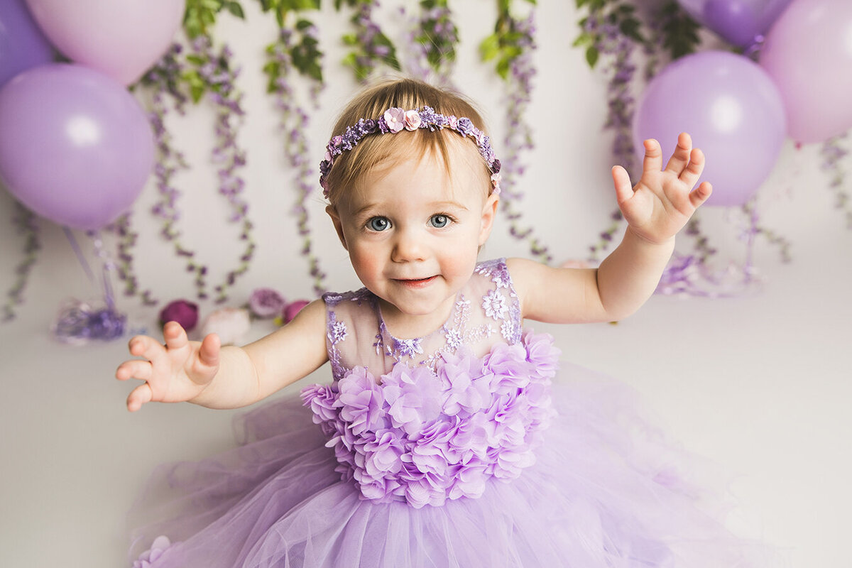 Purple cake smash dress with flowers and cute baby girl