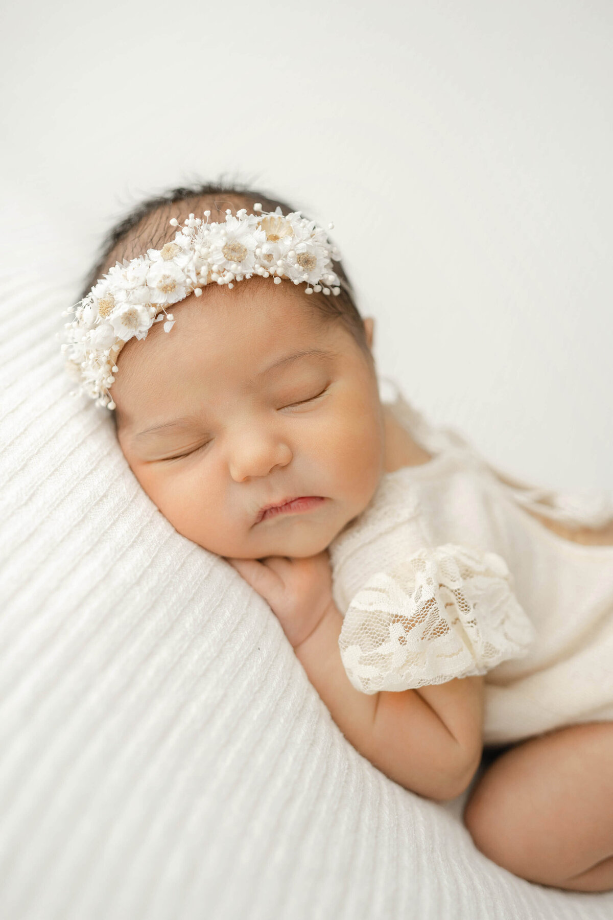 precious sleeping newborn wearing a floral crown in an okc photography studio