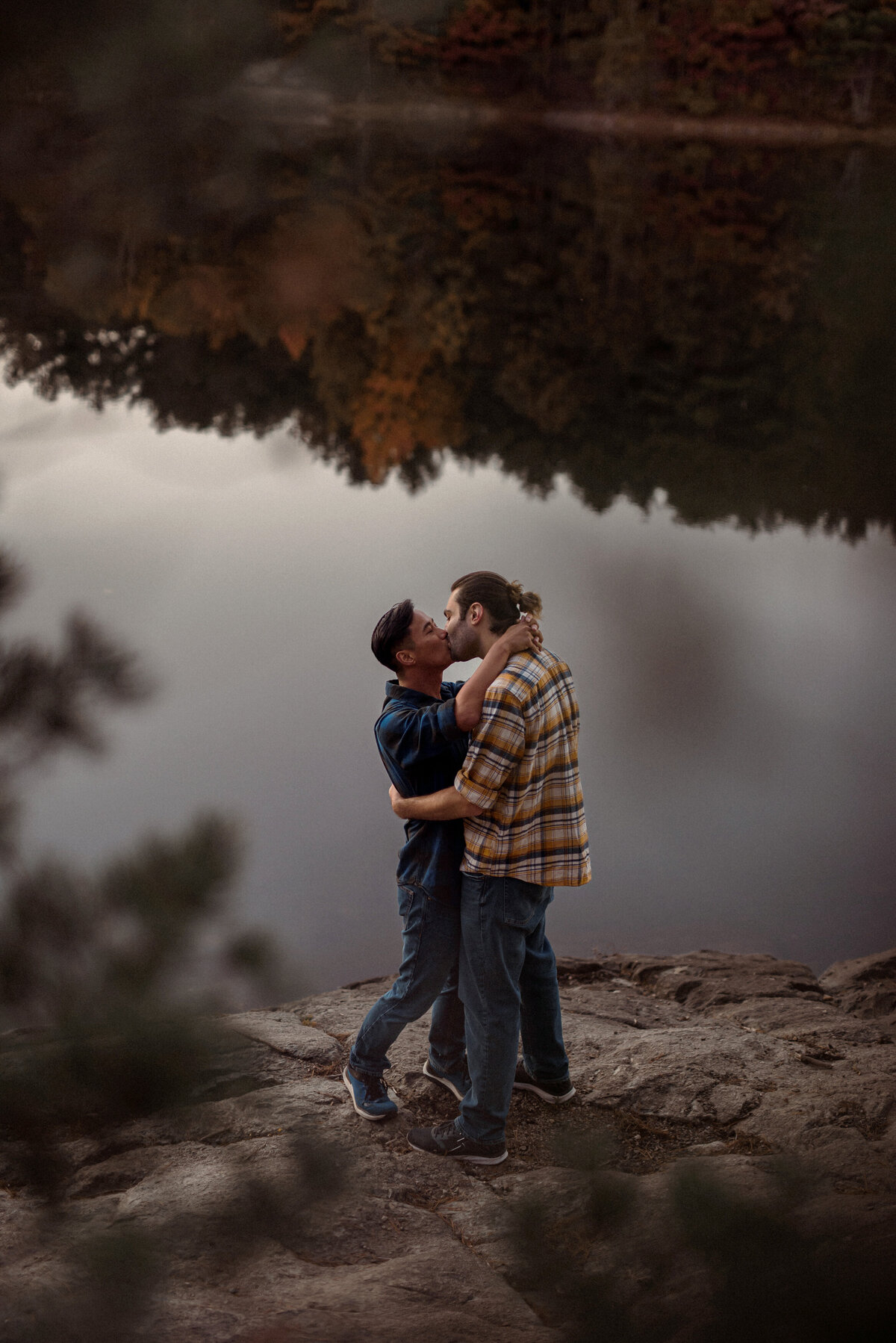 two men engagement session at a lake in the woods on a fall day. a gay couple and lgbtw friendly session. featuring a white man and asian man.